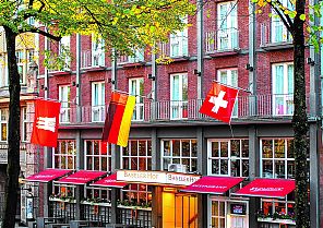 Hotelansicht, Kleinhuis Hotel Baseler Hof mit Flaggen geschmückter Fassade.