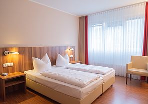 Hotel Das Ebertor, Zimmerbeispiel, Gemütliches Hotelzimmer im Hotel DAS Ebertor mit Doppelbett.